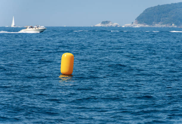 большой желтый надувной сигнальный буй в море - buoy anchored sea wave стоковые фото и изображения