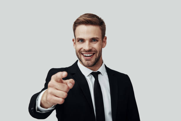 istock Handsome young man in formalwear looking at camera and pointing you while standing against grey background 1170879317