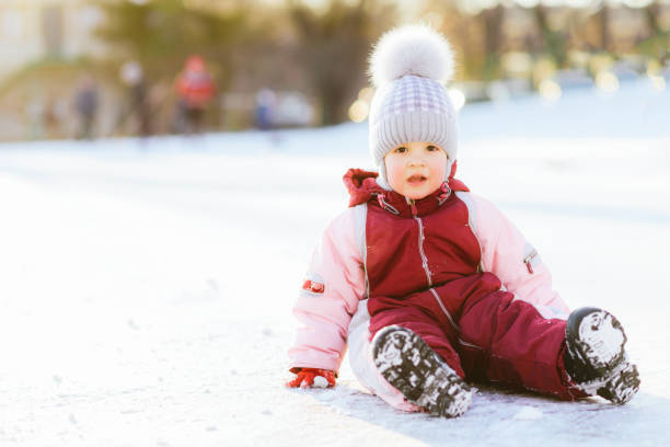 istock little baby is sitting on the snow at sunset 1170879752