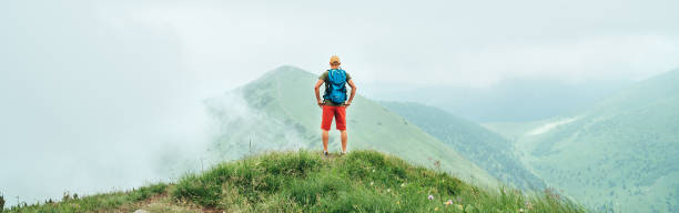 istock Hiker man walking by the cloudy and foggy weather mountain range path with backpack. Active sport backpacking healthy lifestyle concept. 1170880596