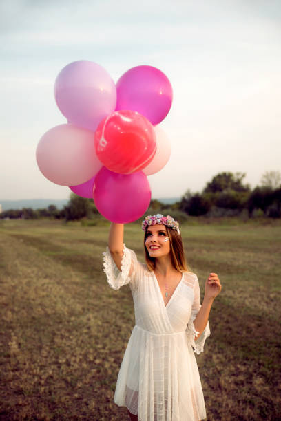 istock Young woman with balloons 1170884216