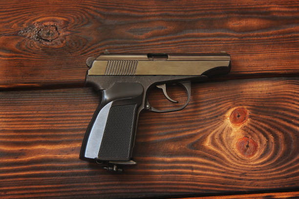 istock Weapon. Gun on the wooden background 1170888339