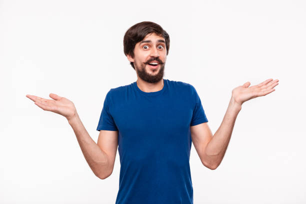 good looking brunet man in a blue shirt with beard and mostaches shrugging his shoulders being clueless standing isolated over white background. emotion and gesture of puzzlement. - blank expression head and shoulders horizontal studio shot imagens e fotografias de stock