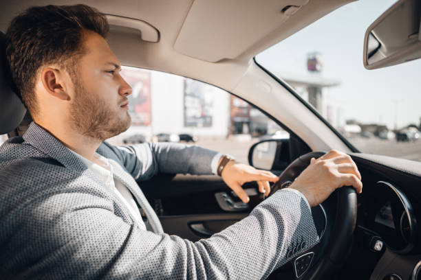 istock Successful businessman in a suit drives his luxary car. 1170895191