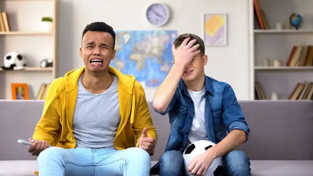 Photo of Anxious multiracial friends unhappy with national football team losing, leisure