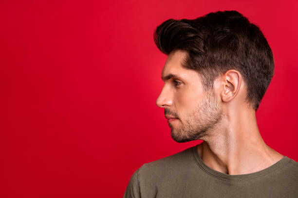 Photo Of Macho Guy Turn Head Side Showing New Hairstyle Wear Grey Tshirt  Isolated On Red Background Stock Photo - Download Image Now - iStock