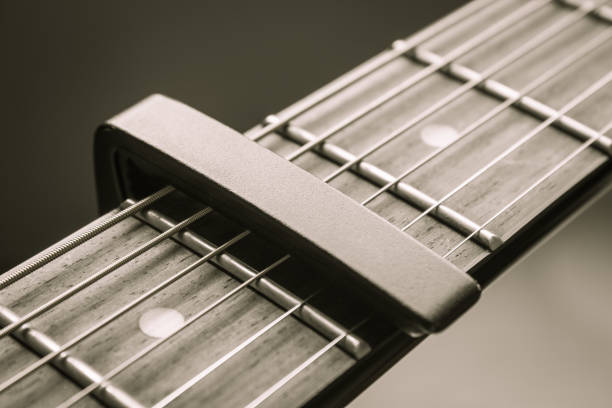 istock Black Capo on Acoustic Guitar String and Fingerboard in Vintage Tone 1170896517