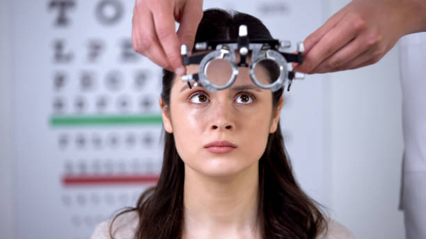 istock Ophthalmologist putting refractor on scared female patient, analyzing eyesight 1170896528