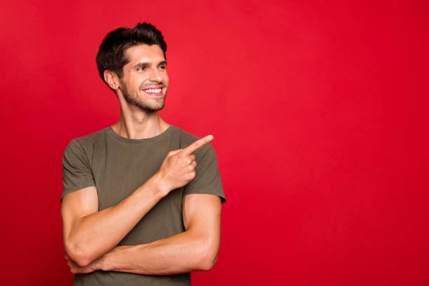 istock Macho guy indicating finger empty space on low shopping spices wear grey t-shirt isolated on red background 1170897643