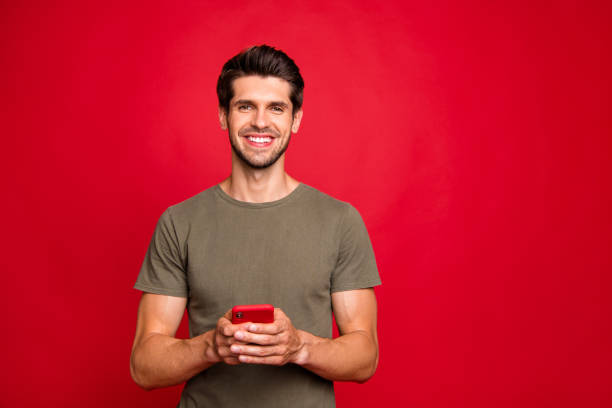 밝은 빨간 배경에 고립 된 현대 전화 손 캐주얼 의상을 들고 놀라운 남자의 클로즈업 사진 - red cell 뉴스 사진 이미지
