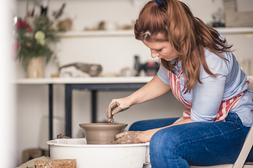 Female artist working on potters wheel