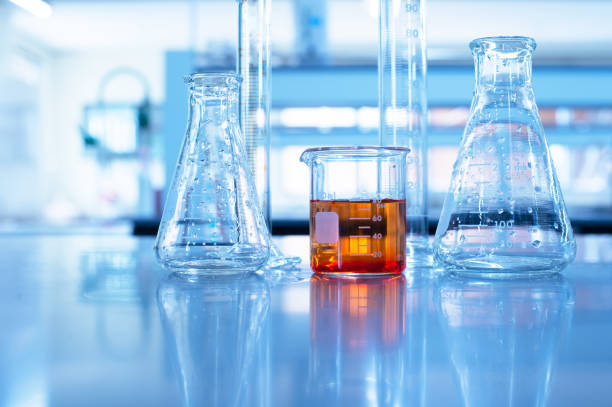 istock glass beaker cylinder and flask with orange solution in chemistry science education blue laboratory background 1170900792