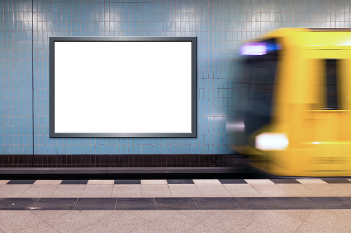 Cartelera neutral en una estación de metro con tren entrante photo