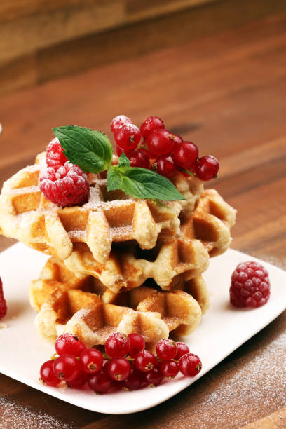 istock Traditional belgian waffles with fresh mint, sugar and raspberries on table 1170902552