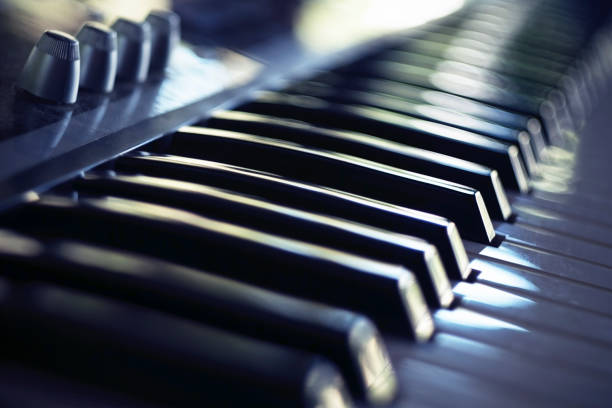 istock Electric piano keyboard in blur. Piano keyboard with day light reflections. 1170902565