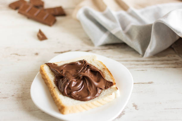Delicious toast bread with chocolate paste on plate closeup.