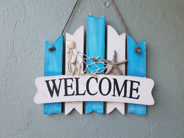 istock blue and white welcome sign with shells on wall 1170902824