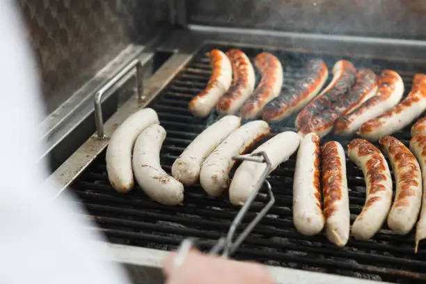 several sausages on a grill getting cooked