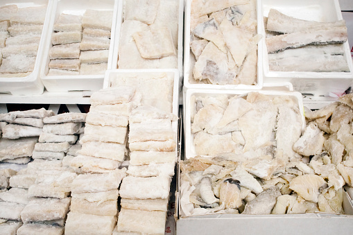 Rows of salted  cod pieces of different sizes and shapes, organized in boxes, sale in  market, Monterroso traditional fair, Lugo province, Galicia , Spain.