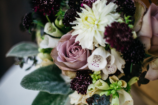 bouquet of beautiful flowers with roses in a small Golden vase in vintage style on the table