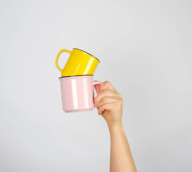 istock female hand holding a stack of ceramic mugs 1170910523