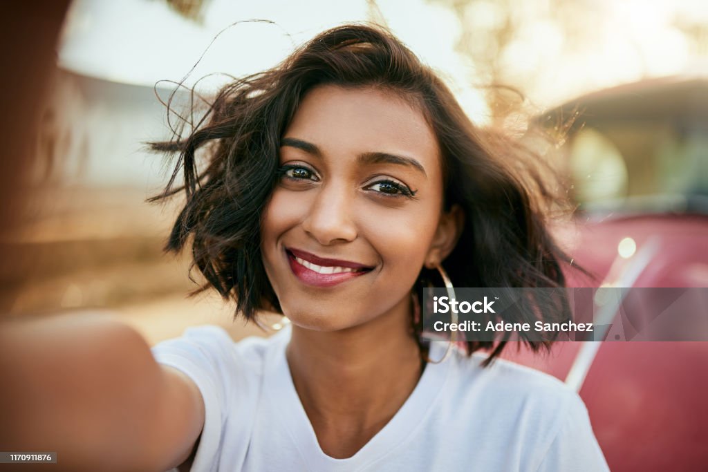 Selfie time Cropped portrait of an attractive young woman standing against her car and taking a selfie alone during a day out Women Stock Photo