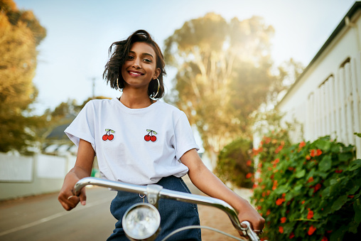 Cropped portrait of an attractive young woman standing and posing with her bicycle during an enjoyable day out