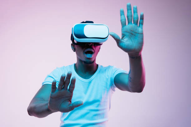istock Young african-american man's using VR-glasses in neon light 1170912006