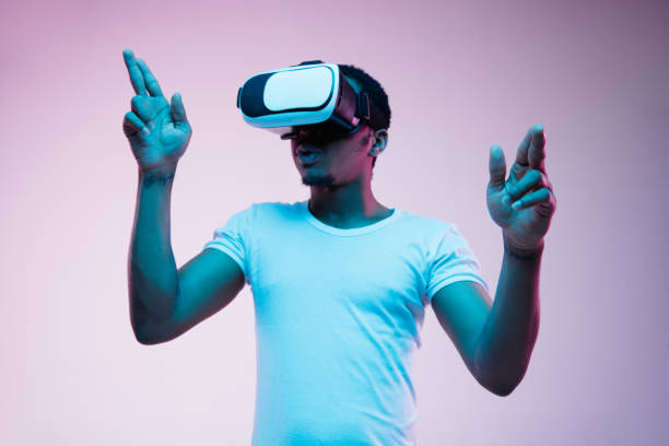 istock Young african-american man's using VR-glasses in neon light 1170912033