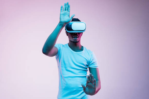 istock Young african-american man's using VR-glasses in neon light 1170912055