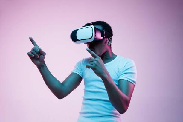 istock Young african-american man's using VR-glasses in neon light 1170912231
