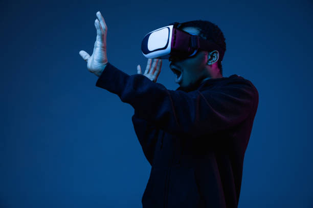 istock Young african-american man's using VR-glasses in neon light 1170912425