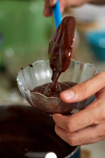 istock Preparing homemade chocolate pudding, closeup on hands 1170913729