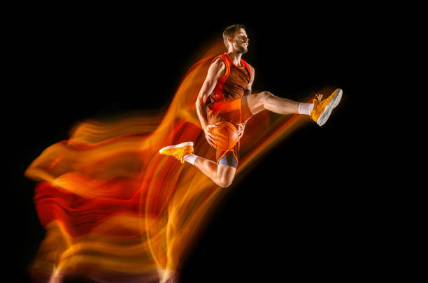 istock Young caucasian basketball player against dark background in mixed light 1170916545