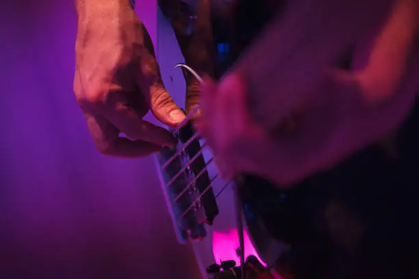 a person playing a guitar on an event with purple light