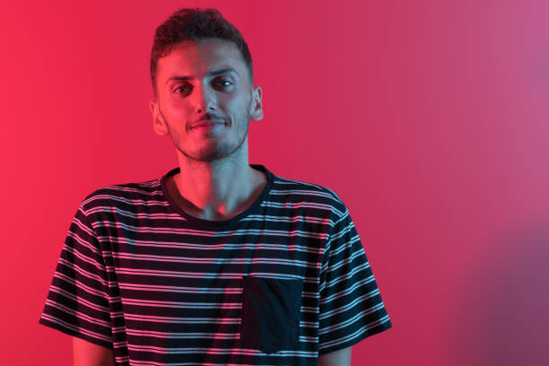 istock Close-up of a handsome young man smiling against neon light 1170923201
