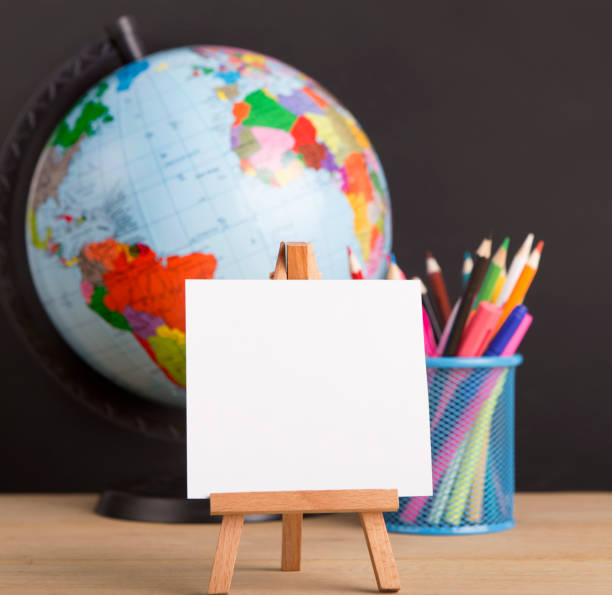 istock Close up of white blank easel for writing text, world globe 1170923396