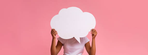 istock Black girl holding an empty speech bubble on pink background 1170923525