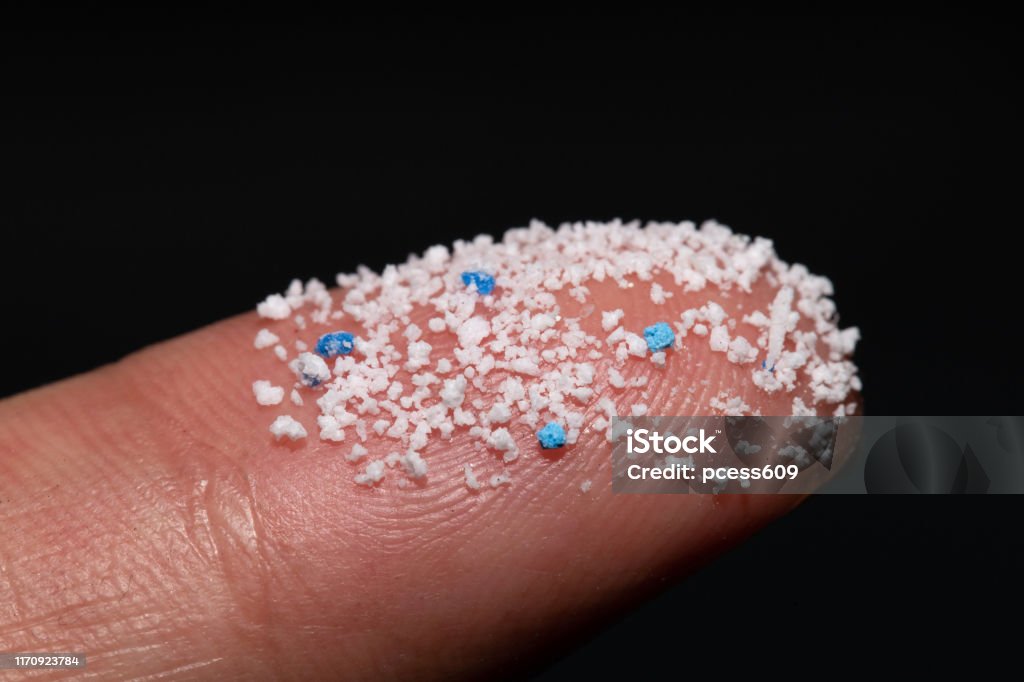 Small Plastic pellets on the finger.Micro plastic.air pollution Microplastic Stock Photo
