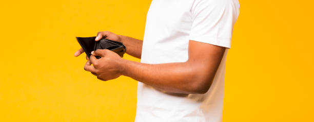 istock Empty wallet in black man hands on yellow background 1170923883