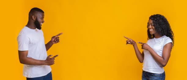 istock Happy black couple pointing at empty space in the middle 1170924459