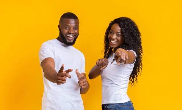 istock Successful afro guy and girl pointing at camera 1170924627