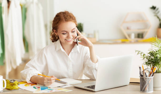 istock Dressmaker talking on phone, discussing sewing order 1170925411