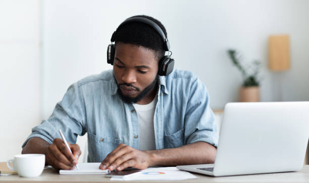 istock Serious african american student in headphones studying foreign language online 1170926149
