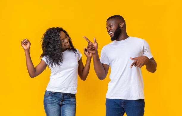istock Attractive black couple dancing on yellow studio background 1170926246