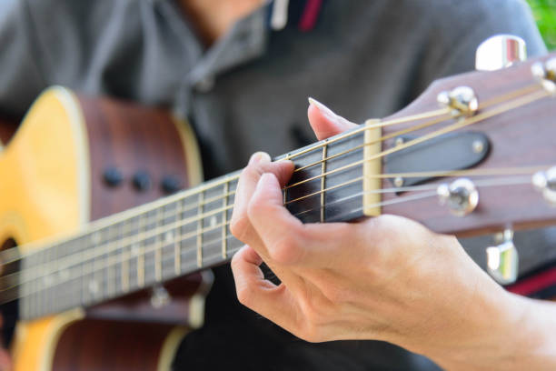 istock Playing acoustic guitar in the park 1170926336