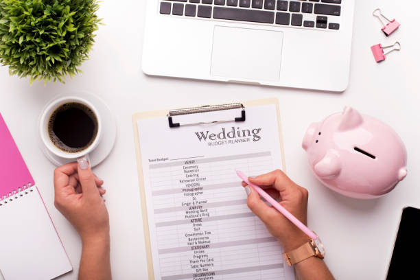 Planning budget before wedding writing ideas on paper Collecting money concept. Woman planning budget before wedding writing ideas on paper piggy bank photos stock pictures, royalty-free photos & images