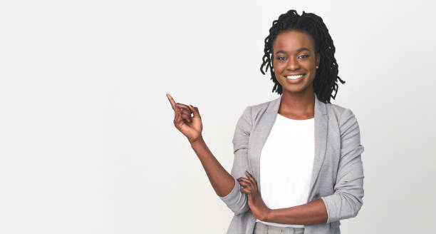 schwarze business lady zeigt finger auf leeren raum auf weiß - zeigen stock-fotos und bilder