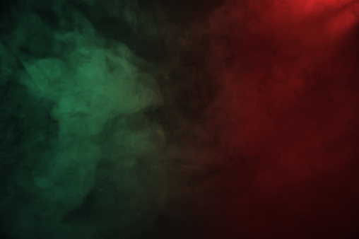 Red and green dense smoke on the dark background