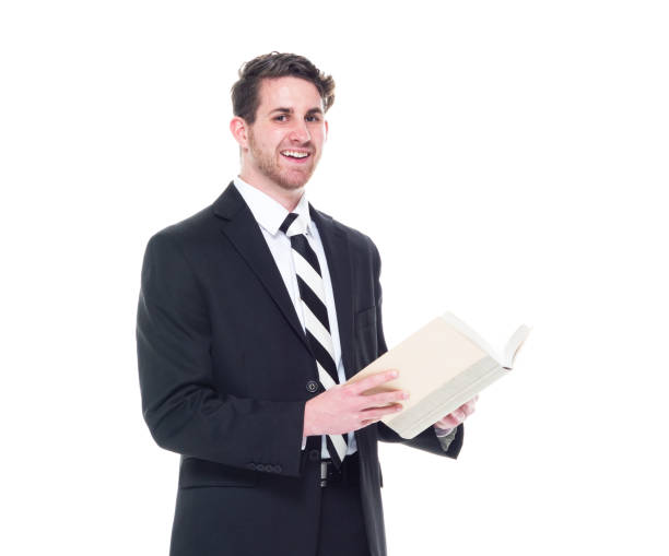 istock Good looking young businessman wearing black suit - holding book 1170930069